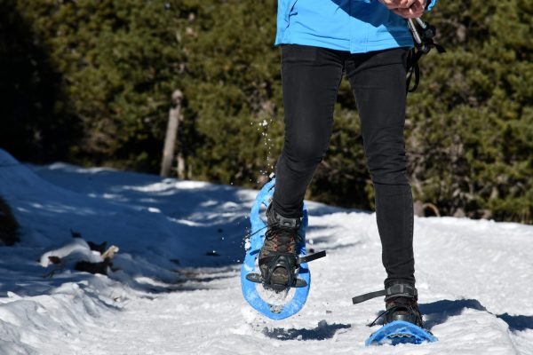 Young,Man,Hiking,With,Snowshoes,On,A,Sunny,Winter,Day Young,Man,Hiking,With,Snowshoes,On,A,Sunny,Winter,Day